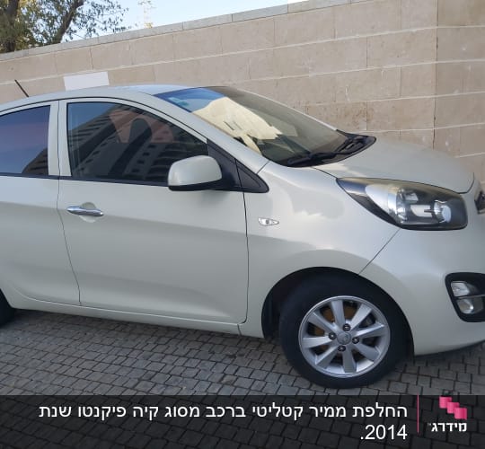מכונית לבנה חונה על מדרכה מרוצפת